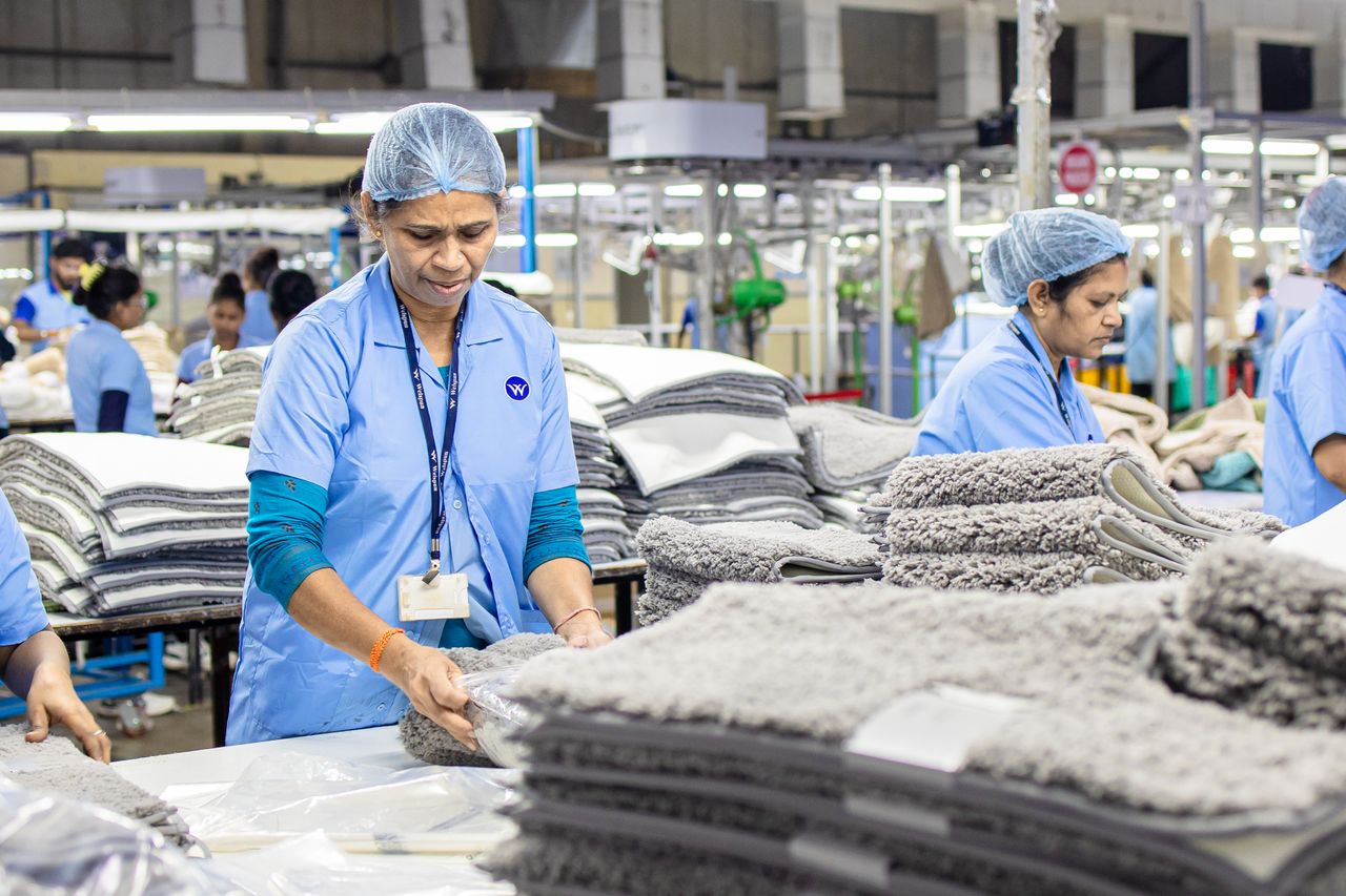 Focused textile factory workers organizing materials efficiently indoors.